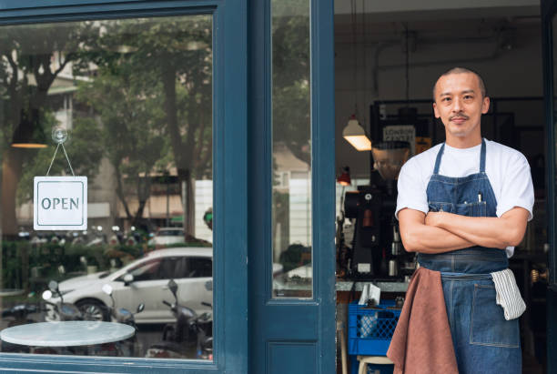 istock Coffee shop owner with Open sign 1473662282