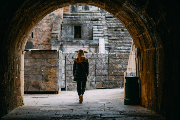 istock Young Woman Exploring Ancient Amphitheater 1473662344