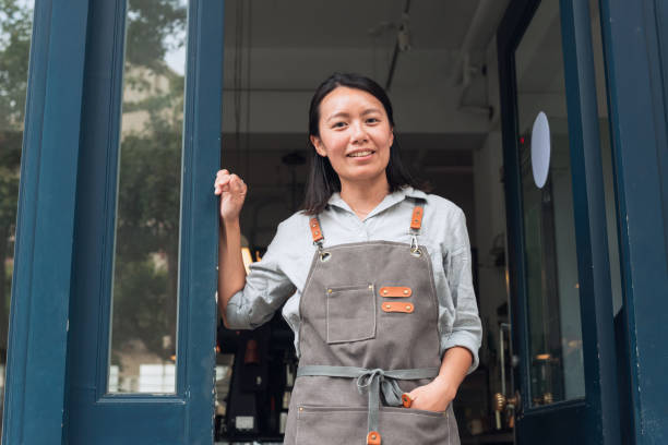 istock Coffee shop owner with Open sign 1473663088