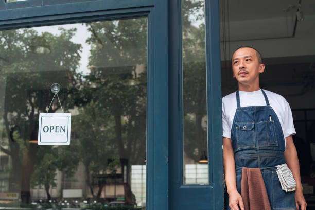 istock Coffee shop owner with Open sign 1473663129
