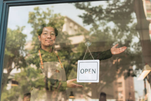 istock Coffee shop owner with Open sign 1473663180