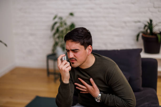 istock An asthmatic young man is using a smoke inhaler at home. 1473663552