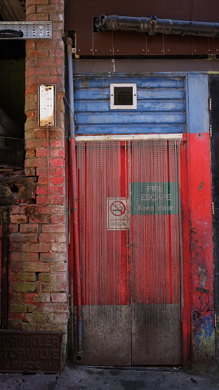 Red fire exit in a back alley in China Town Manchester, England