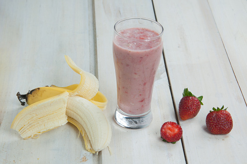 Strawberry and banana smoothies on wooden table. Selective focus.