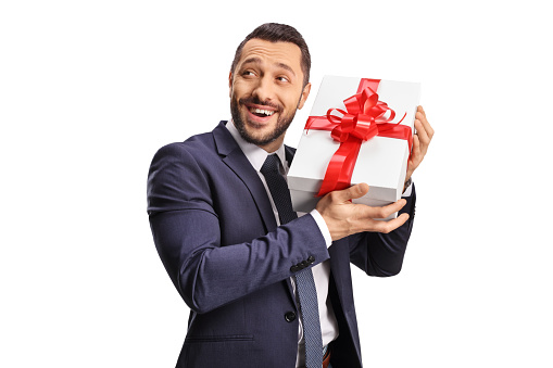 Excited man holding a gift box isolated on white background