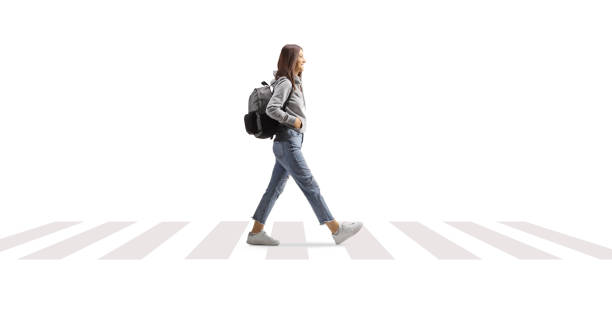 istock Female student with a backpack walking on a pedestrian crossing 1473670017