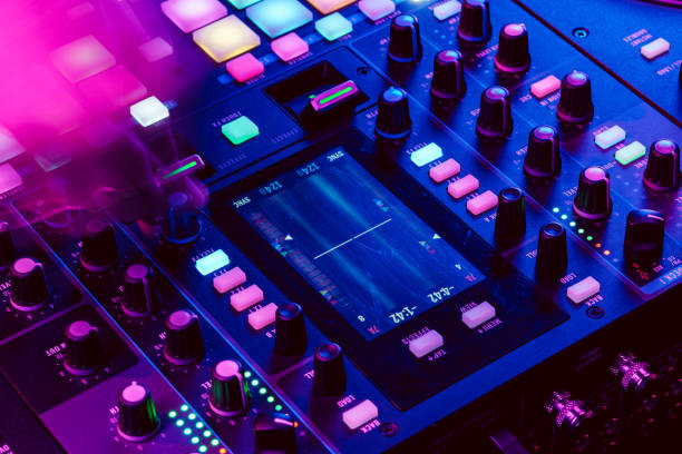 istock Close up of DJ mixing console in party light 1473671342