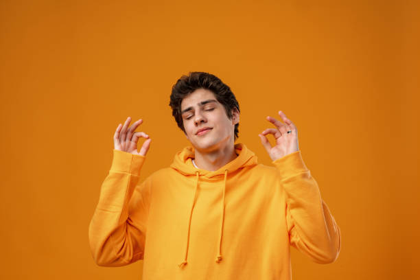 istock Young handsome man over yellow background with eyes closed doing meditation gesture with fingers 1473671597