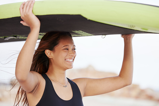 Surfing, happy and woman at the beach with a board for water sports, fitness and summer freedom in Costa Rica. Smile, training and girl surfer with a paddle board for fun on a vacation at the sea