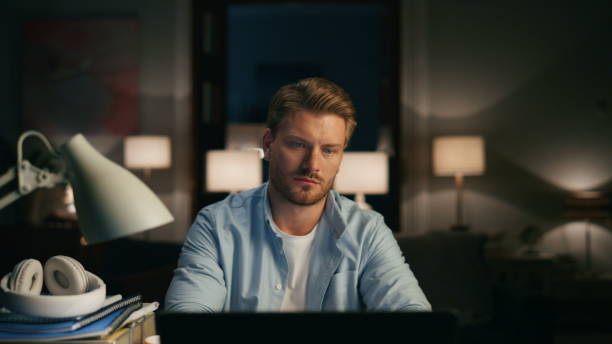 istock Positive man reading desktop at dark interior closeup. Person remote workplace 1473672995
