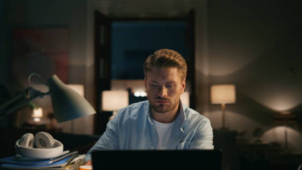 istock Focused guy drinking tea at dark place closeup. Freelancer looking pc monitor 1473673234