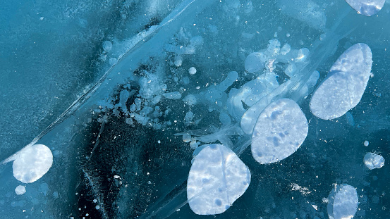 Abstract air bubbles frozen on the ice surface of Lake Baikal in Siberia.