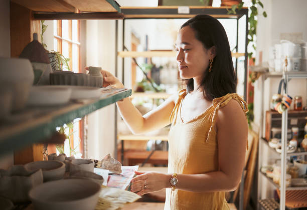 istock Pottery, startup and display with a woman entrepreneur working in a studio, selling products for retail. Small business, manager or sale with a female owner at work in a workshop for artistic design 1473674427