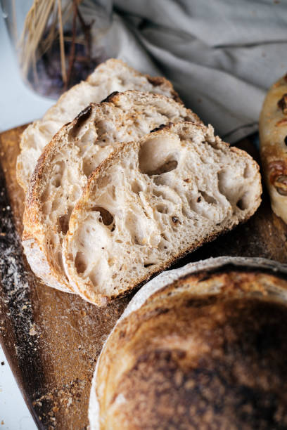 istock Artisan Batard Sourdough healthy Bread with leaf scoring. Open crumb high hydration Sourdough bread set on white table. 1473675094