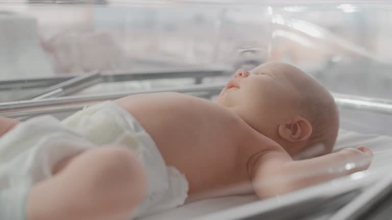 Cute Emotional Newborn Little Infant Lying in Hospital Cot. Funny Yawning Caucasian Baby Spending Time in Maternity Clinic, Getting Ready for Sleep. Healthcare, Pregnancy and Motherhood Concept