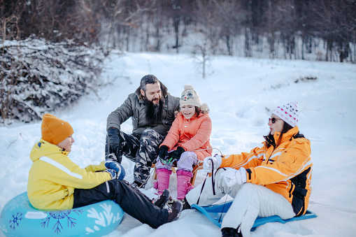 Family spending quality time on snowy mountain in winter