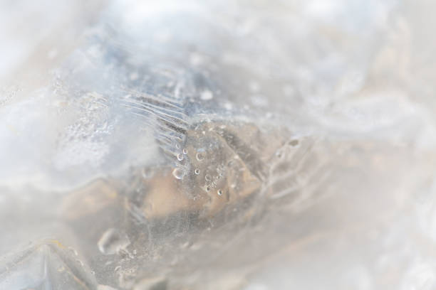 istock Abstract reflection wallpaper or background, with water droplets, defocused plastic wrapping 1473683146