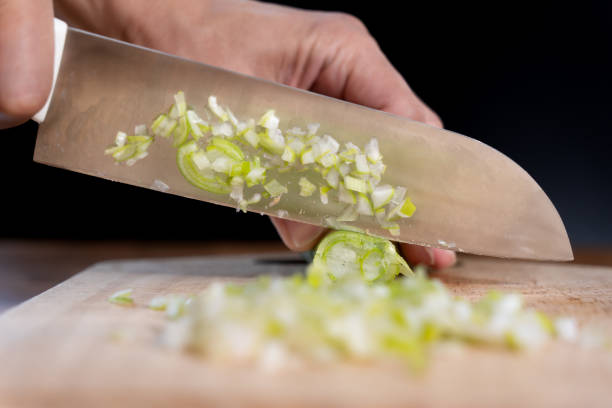istock Men's hands cutting green onions 1473684623