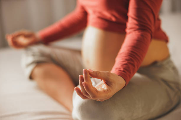 istock Expecting Woman Exercising Yoga On A Bed 1473684929
