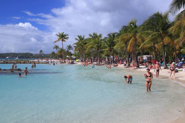 People spend beach vacation in Sainte Anne on Guadeloupe island. Guadeloupe has 650,000 annual visitors.