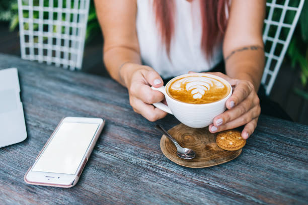 istock Young hipster woman drinking cappuccino while sitting at cafe 1473687786