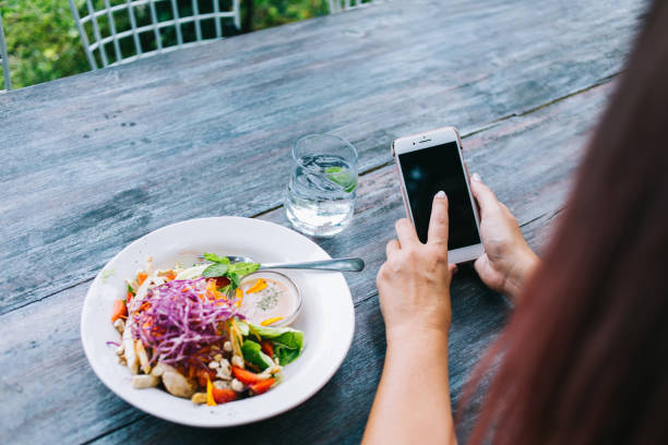 istock Crop woman browsing smartphone and having meal in cafeteria 1473687801