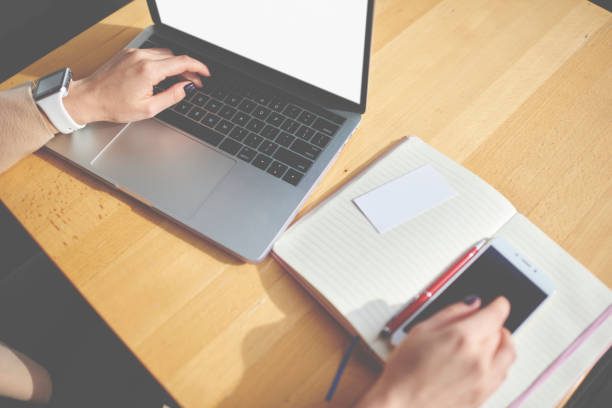 istock Crop unrecognizable woman using laptop and smartphone at desk 1473687832