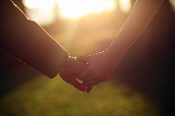 istock Couple holding hands walking in sunset 1473689554
