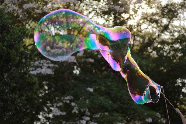 istock Playing With Huge Bubble Against Trees At Park 1473689571