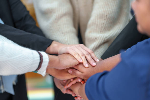 istock A group of friends extended their arms to touch their hands for unity. 1473689656