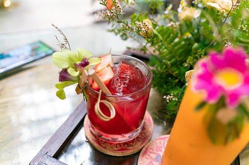glass of strawberry juice decorated with flowers, blurred foreground and background for focus