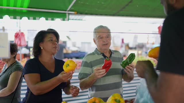Senior couple buying peppers on a street market