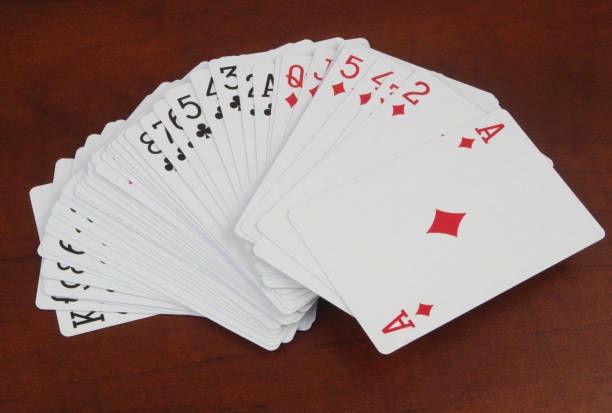 istock Many playing cards on wooden table close up. 1473694808