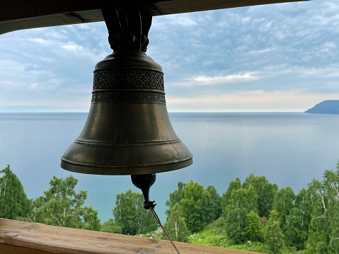 Bell in the belfry of a Christian church against the backdrop of Lake Baikal, Russia