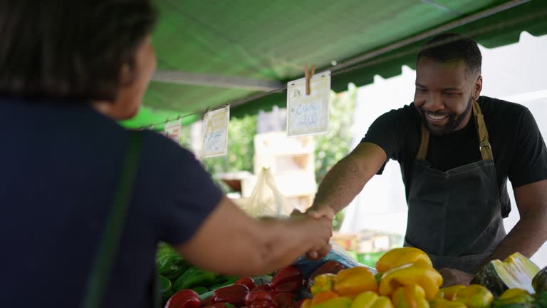 Saleman greeting his customer on a street market