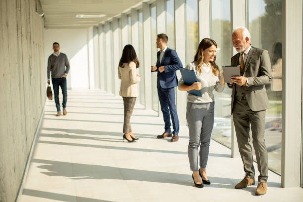 istock Modern business people using digital tablet in the office corridor 1473698873