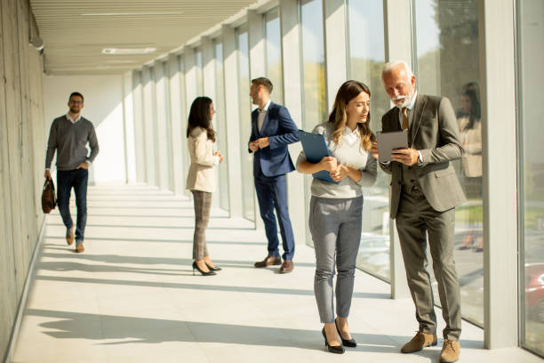 istock Modern business people using digital tablet in the office corridor 1473698880