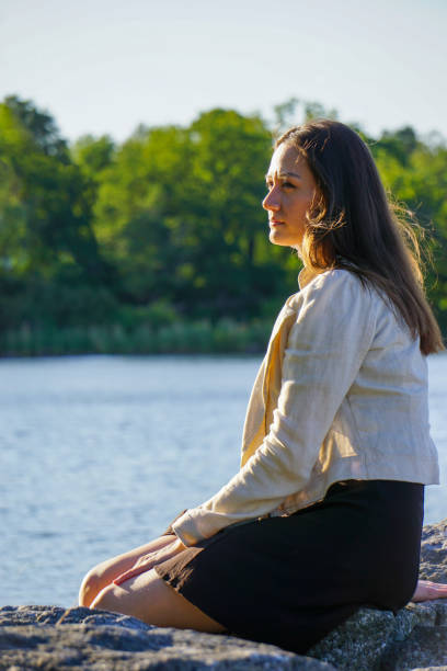 Woman resting while sitting on rock at beach
