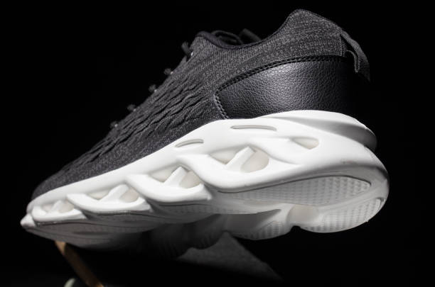 istock Black fabric sneakers with a white sole on a black background. 1473700592