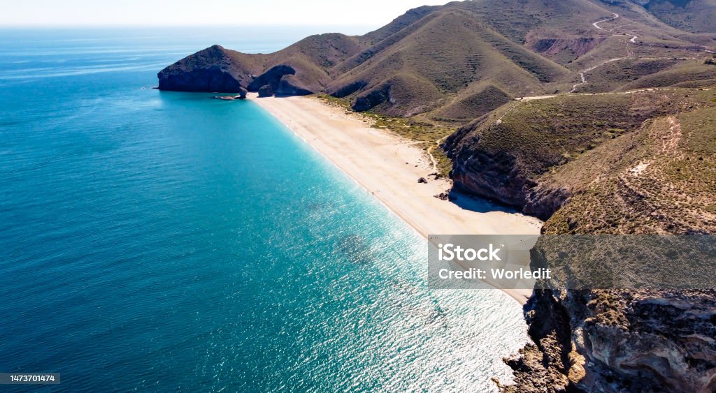 Drone aerial view of seashore, coastline, scenic view of people at unspoiled beach in Almeria, called Playa de los Muertos Seashore, coastline, scenic view of people at unspoiled beach in Almeria, called Playa de los Muertos, in English The beach of Deads due to the strong currents that cause many deaths year after year Beach Stock Photo