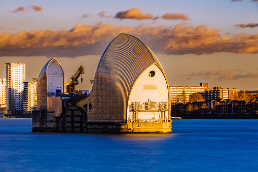 A view of the Thames Barrier - river structures designed to protect London from flooding - at sunset.