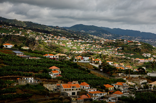 Houses with red roofs on the slopes of the mountains of Madeira island in the Atlantic ocean