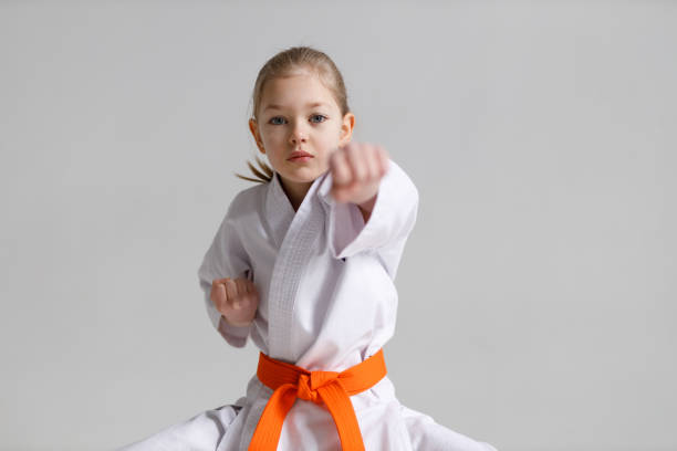 istock Little girl in karate training, punch. 1473706371