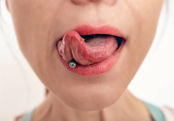 nahaufnahme des mundes der frau mit herausgestreckter zunge. piercing auf der zunge einer frau. - pierced jewelry women body stock-fotos und bilder