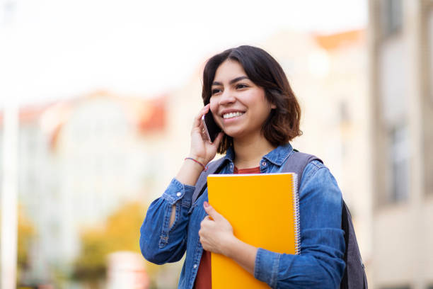 istock Happy Middle Eastern Student Female Talking On Cellphone While Walking Outdoors 1473707812