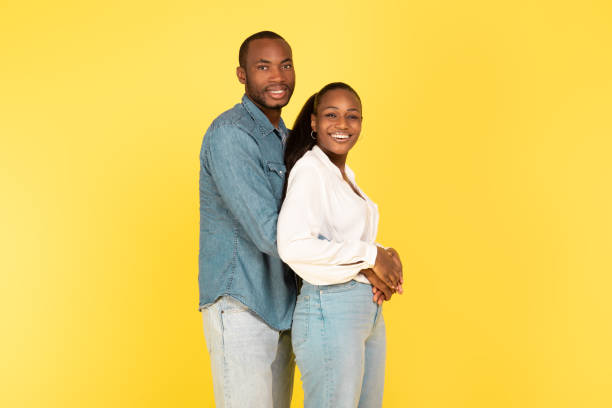 istock Loving Black Couple Embracing Posing Standing Over Yellow Background 1473707844