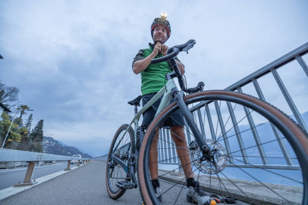 istock Man cyclist training at dusk, takes a break on bicycle lane 1473707857