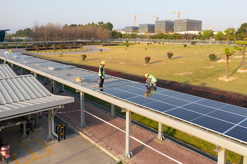 Workers install solar panels at a public corridor on Fangshan West Road, Xiang'an District, Xiamen, Fujian Province, China
