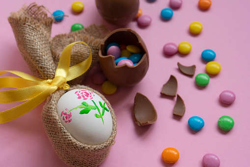 Easter chocolate eggs and candies on a pink background