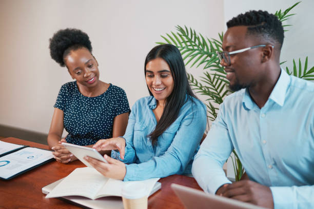istock Young business woman explains to colleagues using tablet at office boardroom 1473709583